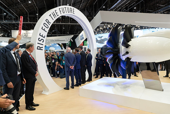 Envers du décor, photo de groupe avec Emmanuel Macron sur le stand en 2023